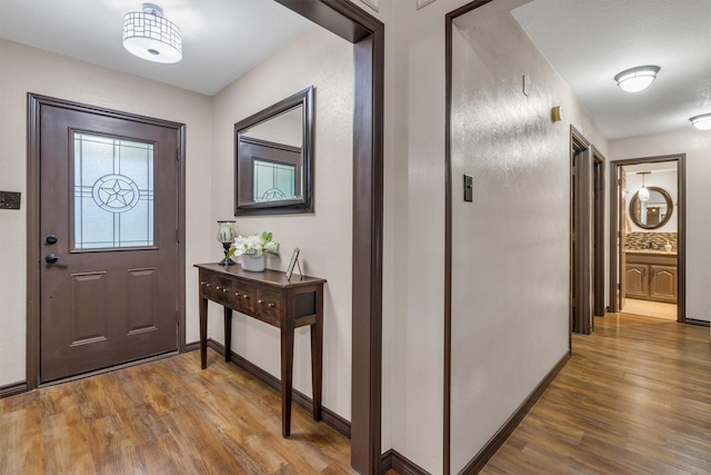 foyer entrance featuring wood finished floors and baseboards