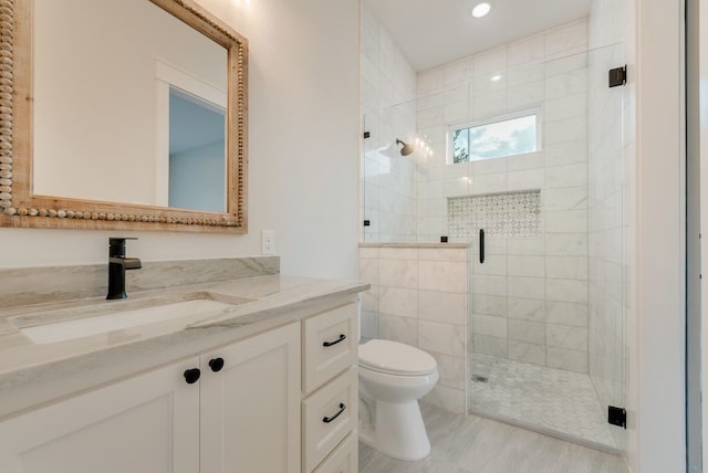 bathroom featuring toilet, a stall shower, vanity, and recessed lighting
