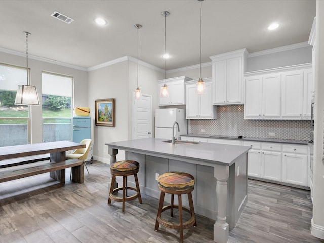 2209 Trace Ridge Dr, Weatherford, TX 76087 - kitchen featuring a sink, baseboards, a kitchen island with sink, crown molding, and white cabinets