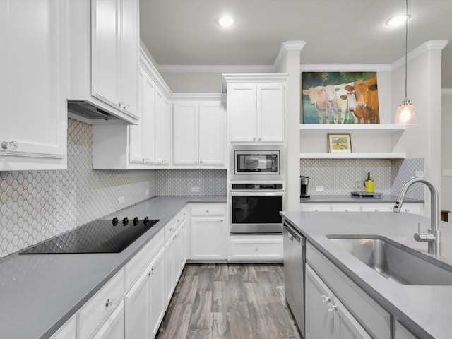 2209 Trace Ridge Dr, Weatherford, TX 76087 - kitchen featuring appliances with stainless steel finishes, a sink, ornamental molding, backsplash, and hanging light fixtures