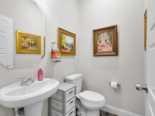 2209 Trace Ridge Dr, Weatherford, TX 76087 - half bath featuring a sink, toilet, and baseboards