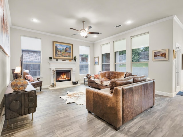 2209 Trace Ridge Dr, Weatherford, TX 76087 - living area with ceiling fan, healthy amount of natural light, a lit fireplace, light wood-style floors, and crown molding