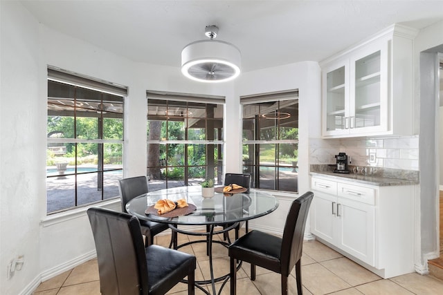 dining space featuring light tile patterned flooring and baseboards