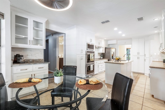 dining space with recessed lighting and light tile patterned floors