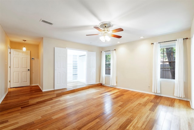 unfurnished room featuring plenty of natural light, light wood-style floors, a ceiling fan, baseboards, and recessed lighting