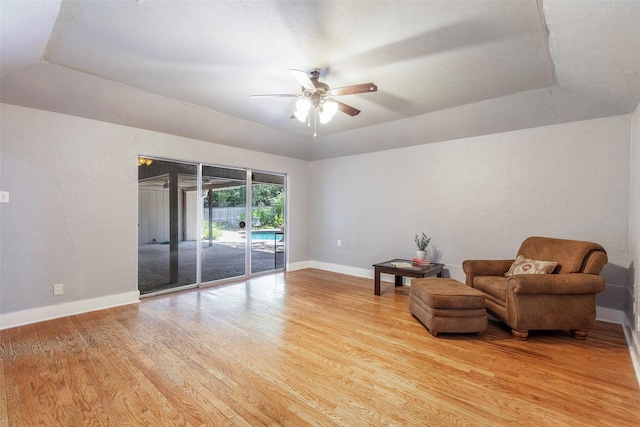 sitting room featuring light wood-type flooring, a ceiling fan, and baseboards