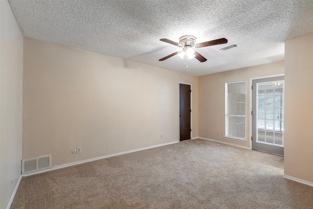 empty room with carpet floors, a ceiling fan, baseboards, and a textured ceiling