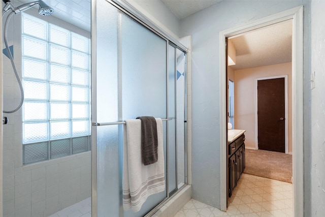 bathroom with a stall shower, vanity, and tile patterned floors