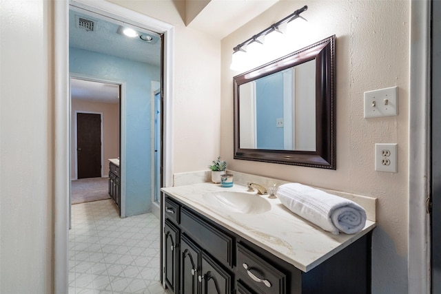 full bathroom featuring tile patterned floors, vanity, and a shower