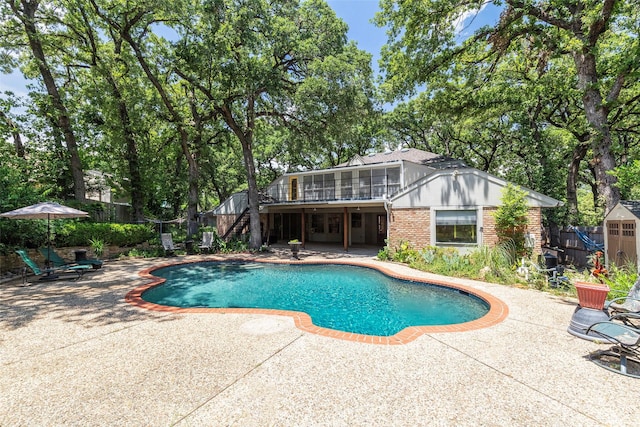 view of pool featuring stairway, a patio, fence, and a deck