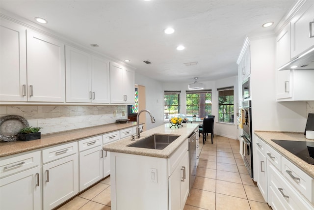 kitchen featuring a sink, recessed lighting, white cabinetry, stainless steel appliances, and light tile patterned floors