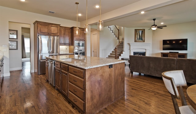 4625 Man O War Rd, Carrollton, TX 75010 - kitchen featuring appliances with stainless steel finishes, light stone countertops, ceiling fan, dark wood-style flooring, and recessed lighting