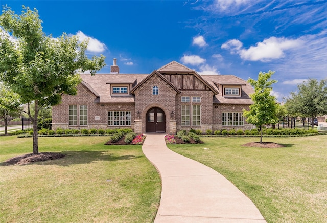 4625 Man O War Rd, Carrollton, TX 75010 - tudor house with brick siding, a front yard, stone siding, and a chimney