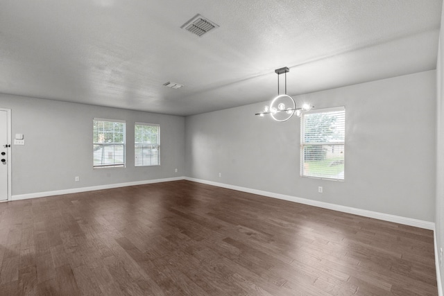 2720 Ocaso Dr, Little Elm, TX 75068 - unfurnished room featuring dark wood-type flooring, a chandelier, and baseboards