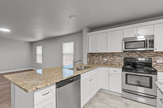 2720 Ocaso Dr, Little Elm, TX 75068 - kitchen featuring stainless steel appliances, a sink, a peninsula, and backsplash