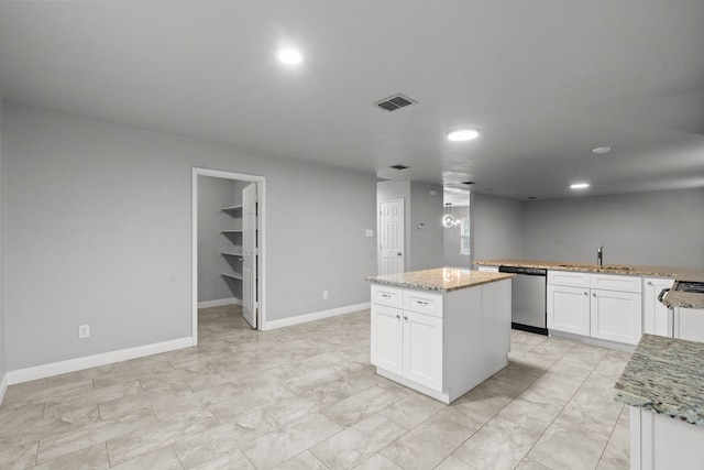 2720 Ocaso Dr, Little Elm, TX 75068 - kitchen with stainless steel dishwasher, a sink, white cabinetry, and a kitchen island