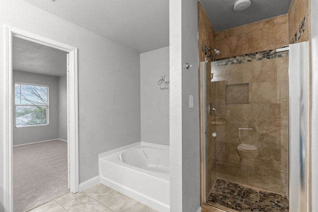 2720 Ocaso Dr, Little Elm, TX 75068 - bathroom with a shower stall, a bath, baseboards, and tile patterned flooring