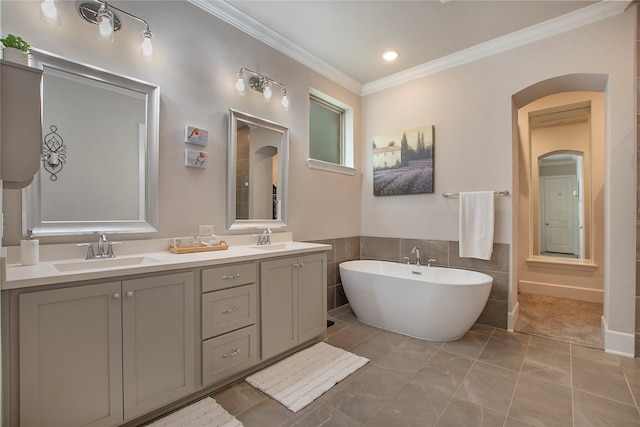 2700 Tremont Blvd, Mckinney, TX 75071 - full bath with a freestanding bath, ornamental molding, double vanity, tile walls, and wainscoting