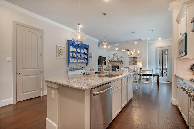 2700 Tremont Blvd, Mckinney, TX 75071 - kitchen with a sink, stainless steel appliances, a brick fireplace, dark wood-style floors, and white cabinets