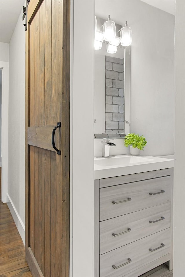 bathroom featuring wood finished floors, vanity, and baseboards