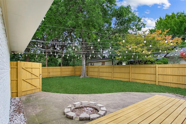 view of yard featuring an outdoor fire pit and a deck
