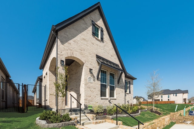 view of front of house with brick siding and a gate