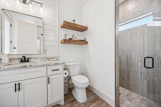 2028 Carrie Ct, Weatherford, TX 76088 - bathroom featuring tiled shower, toilet, wood finished floors, vanity, and baseboards