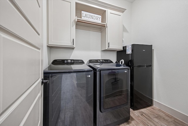 2028 Carrie Ct, Weatherford, TX 76088 - laundry room featuring cabinet space, washing machine and dryer, light wood-style flooring, and baseboards