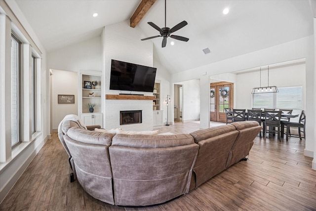 2028 Carrie Ct, Weatherford, TX 76088 - living area featuring high vaulted ceiling, beamed ceiling, a fireplace, a ceiling fan, and wood finished floors