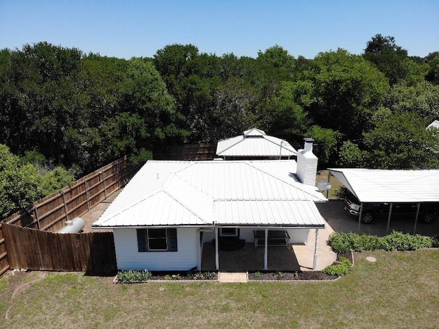 120 One Feather, Whitney, TX 76692 - back of property featuring a chimney, metal roof, and a wooded view