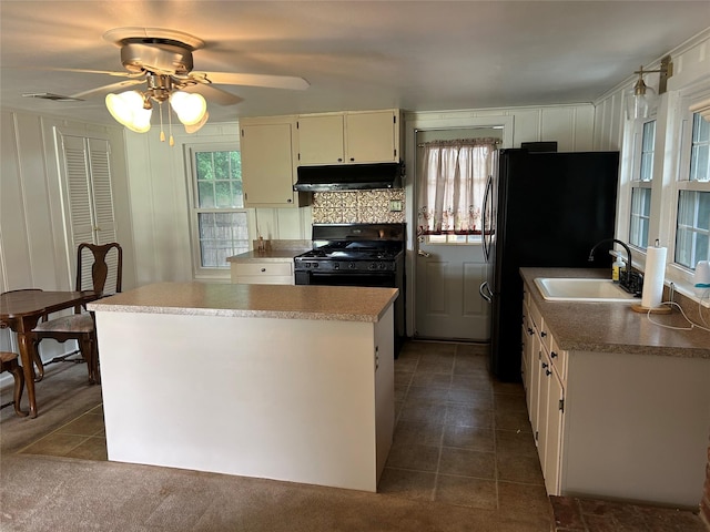 120 One Feather, Whitney, TX 76692 - kitchen featuring under cabinet range hood, black appliances, ceiling fan, a sink, and a kitchen island