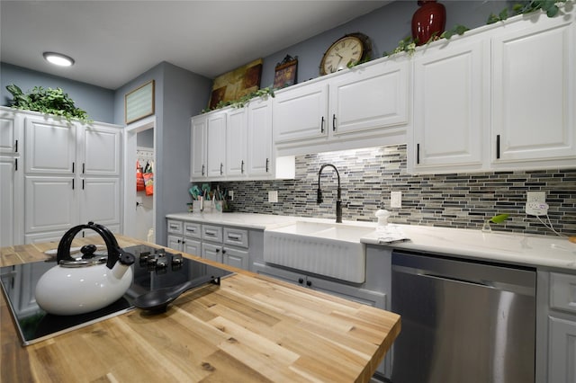 kitchen featuring stainless steel dishwasher, wooden counters, a sink, tasteful backsplash, and wood finished floors
