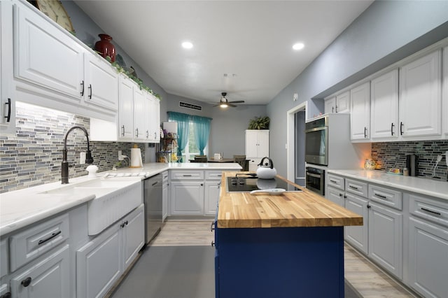 kitchen featuring wood counters, dishwasher, a sink, a ceiling fan, and black electric cooktop