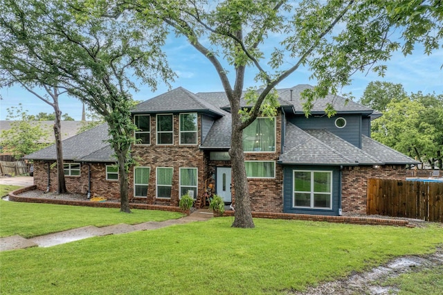 view of front of home featuring a shingled roof and brick siding