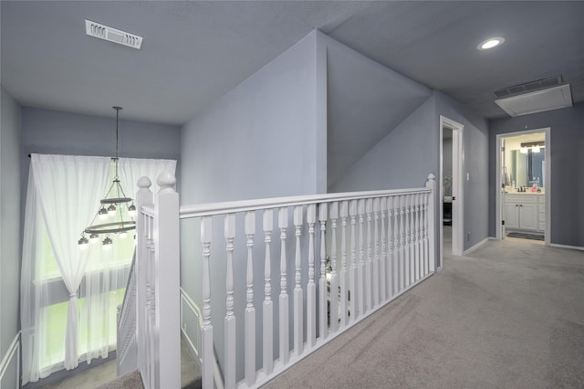 corridor featuring attic access and an upstairs landing
