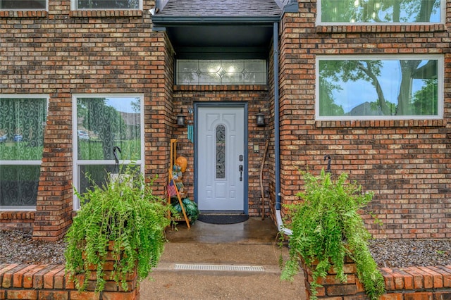 view of exterior entry featuring brick siding