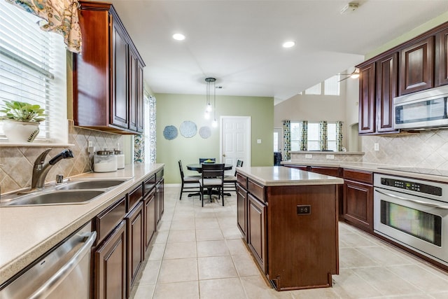 kitchen with stainless steel appliances, a sink, backsplash, light countertops, and recessed lighting