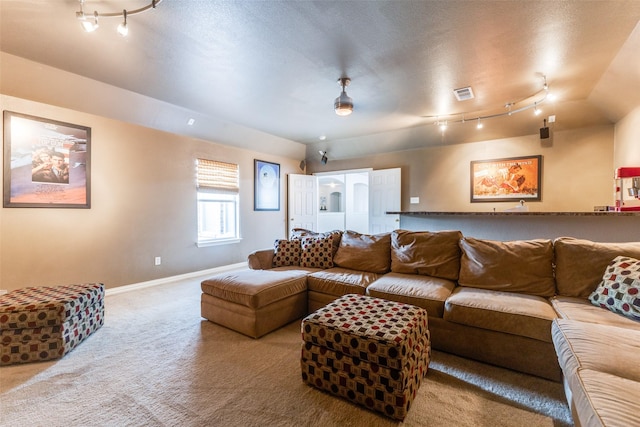 living area featuring carpet flooring, baseboards, and rail lighting