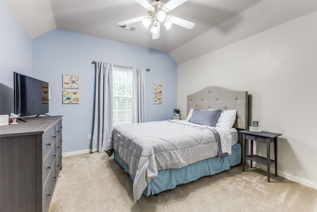 bedroom with vaulted ceiling, light colored carpet, baseboards, and a ceiling fan