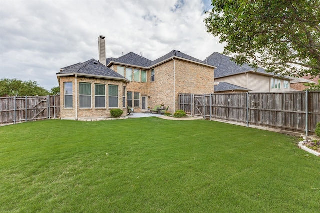 back of property featuring a chimney, brick siding, and a patio