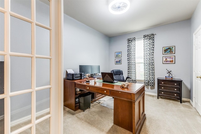 office area featuring light carpet and baseboards