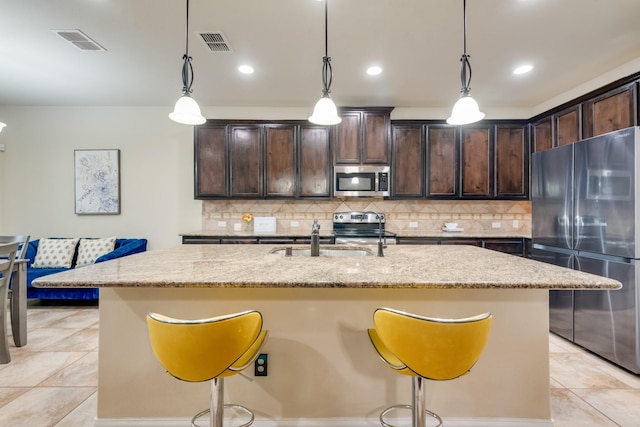 2015 Diamondback, Forney, TX 75126 - kitchen with stainless steel appliances, a sink, a kitchen bar, light stone countertops, and dark brown cabinetry