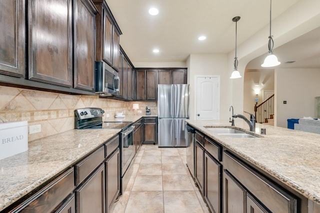 2015 Diamondback, Forney, TX 75126 - kitchen with stainless steel appliances, a sink, dark brown cabinets, backsplash, and light stone countertops