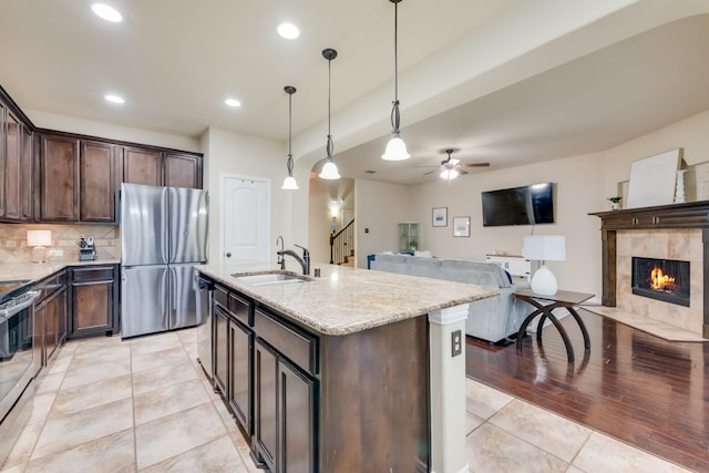 2015 Diamondback, Forney, TX 75126 - kitchen featuring appliances with stainless steel finishes, a sink, dark brown cabinetry, light stone countertops, and light tile patterned floors