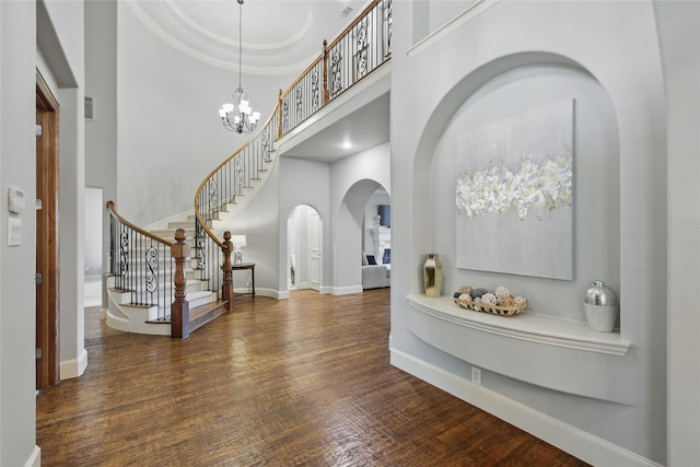 924 Mckamy Dr, Allen, TX 75013 - foyer entrance featuring arched walkways, a towering ceiling, wood finished floors, stairway, and a chandelier