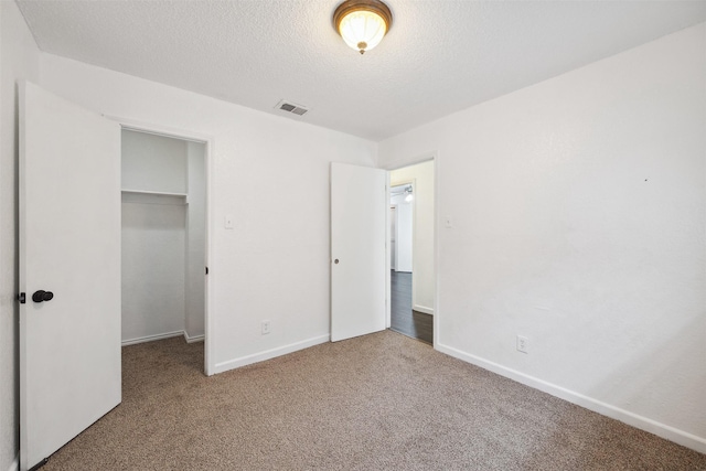 2634 Pinta Cir, Grand Prairie, TX 75052 - unfurnished bedroom with carpet flooring, a closet, a textured ceiling, a spacious closet, and baseboards