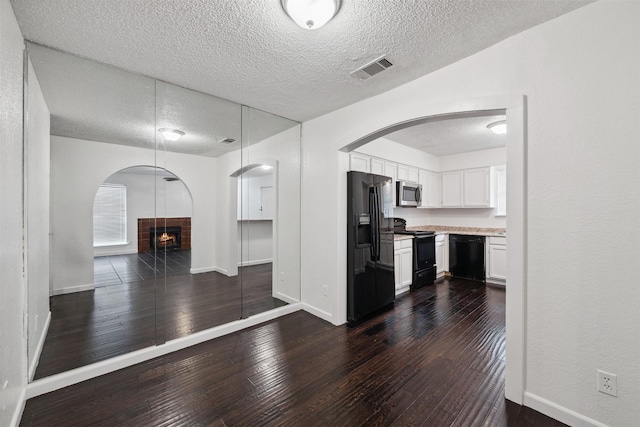 2634 Pinta Cir, Grand Prairie, TX 75052 - kitchen with black appliances, a textured ceiling, open floor plan, light countertops, and dark wood-style flooring