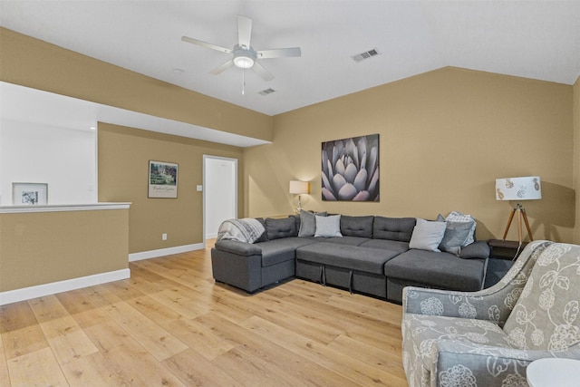 living area featuring light wood finished floors, ceiling fan, baseboards, and vaulted ceiling