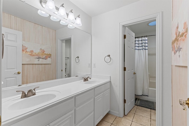 bathroom featuring tile patterned floors, double vanity, shower / bath combo with shower curtain, and baseboards