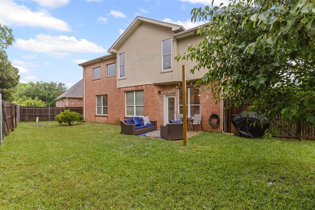 rear view of property with an outdoor hangout area, brick siding, stucco siding, and a patio area